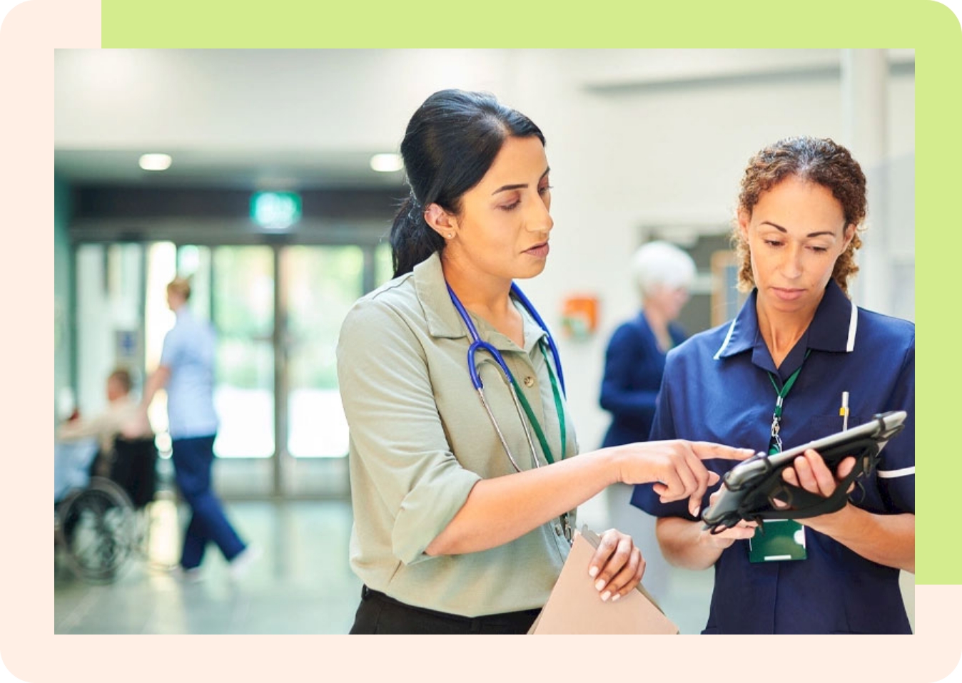 two female medical professionals review information on a tablet