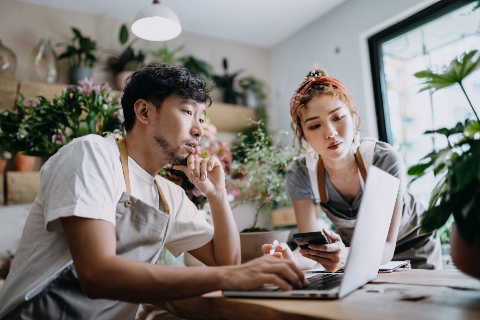 Two people in flower shop looking at data on computer